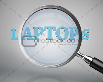 Magnifying glass showing laptops word