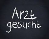 German word arzt gesucht written on a blackboard
