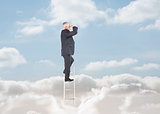 Businessman standing on a ladder over clouds