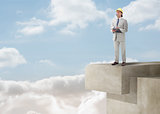 Architect standing on a building over the clouds