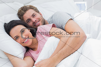 Couple embracing in bed