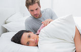 Sad woman ignoring her partner in her bed