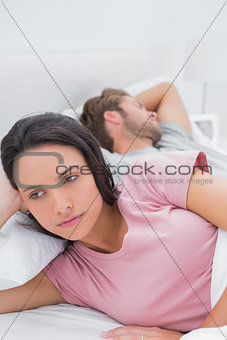 Thoughtful woman lying in her bed