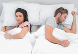 Woman looking at camera while her husband is sleeping