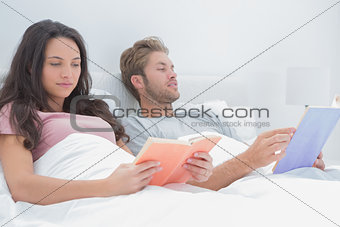 Couple reading in their bed