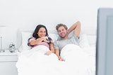 Couple watching tv in their bed