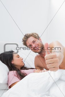Man giving thumb up next to his sleeping partner