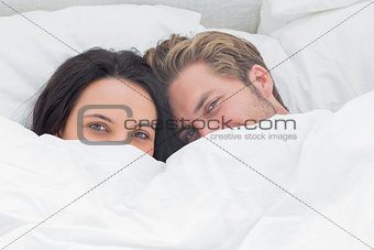 Couple hiding under the duvet