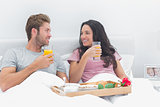 Beautiful couple having breakfast in bed
