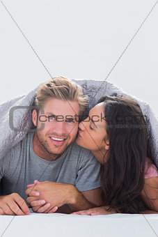 Woman kissing her husband while they are hand in hand