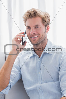 Man smiling while he is having a phone conversation