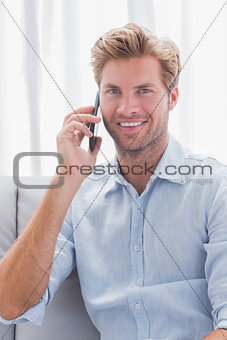 Man smiling while he is having a phone conversation