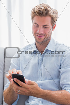 Man using his smartphone on a couch