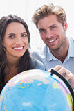 Portrait of a beautiful couple looking at a globe