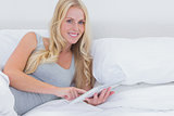 Woman using a tablet in bed