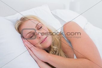 Blonde woman sleeping in her bed
