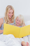 Mother reading a story to her cute daughter
