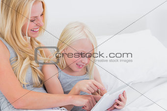 Mother and daughter touching a tablet