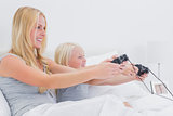 Mother and daughter having fun playing video games