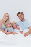 Portrait of a happy family in bed