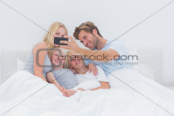 Cheerful family taking self pictures with a smartphone