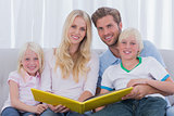Portrait of a family holding a story book