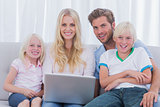 Cheerful family using a laptop