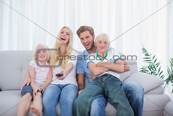 Laughing family watching TV together