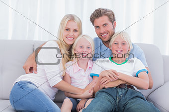 Smiling family sitting on couch