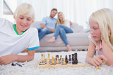 Children playing chess in the living room