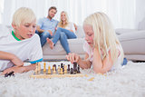 Parents looking at their children playing chess
