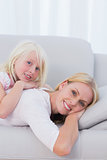 Mother with her daughter lying on couch