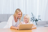 Woman using laptop with her daughter
