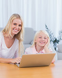 Mother and daughter using laptop in the living room