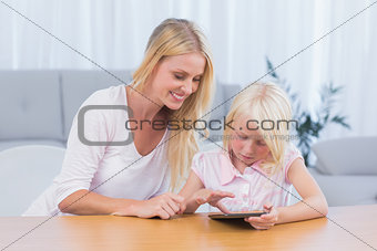 Mother using digital tablet with her daughter