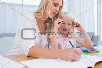 Cute little girl with her mother drawing