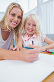 Mother and daughter drawing at table