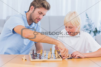 Father and his son playing chess
