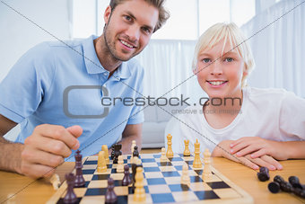 Father and his little boy playing chess