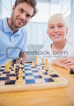 Father playing chess with his little boy