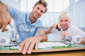 Father and son repairing a skateboard