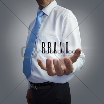 Businessman holding the word brand