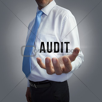 Businessman holding the word audit