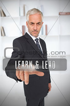 Serious businessman touching the term learn and lead