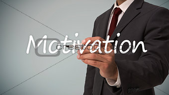 Businessman writing the word motivation