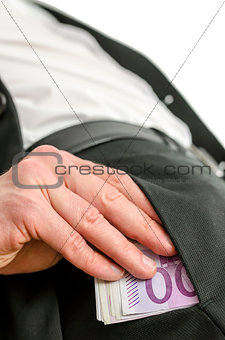 Bottom view of businessman putting money in his pocket