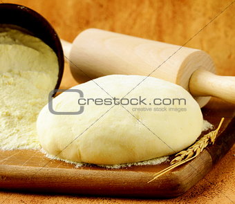homemade dough  and flour on a wooden board