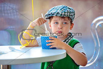 Cute little boy eating ice cream at indoor cafe