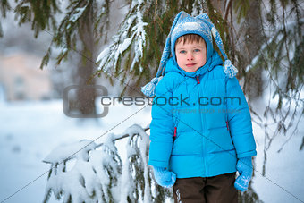 Cute little boy playing outdoors in a winter forest