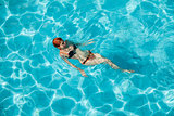Young redhead woman in swimming pool 